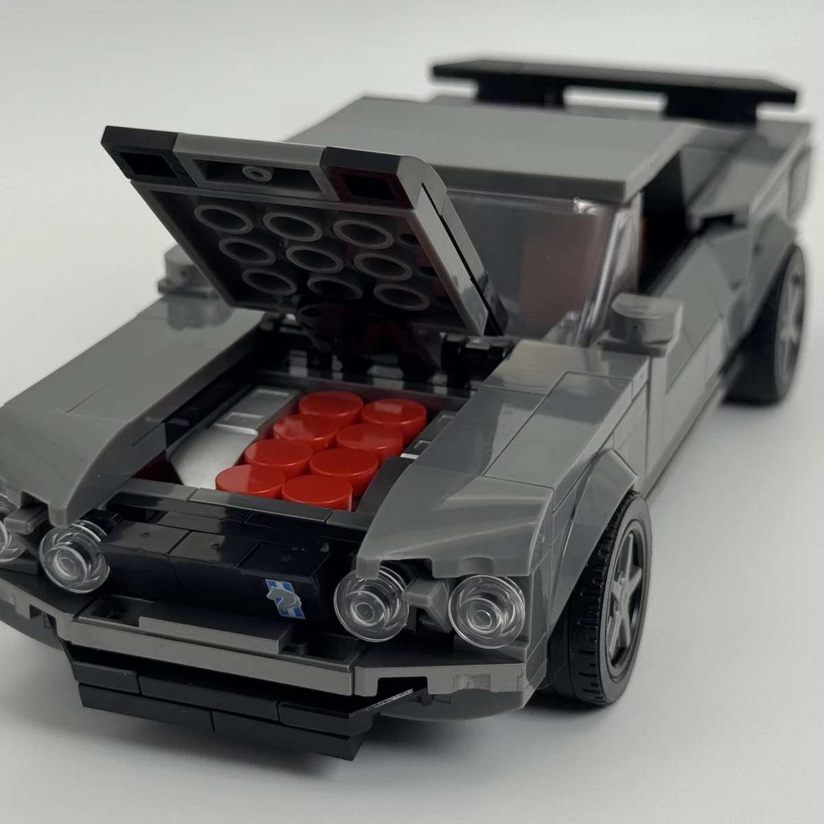 Front view of the Mustang brick model with its bonnet open to reveal red V8 engine details.