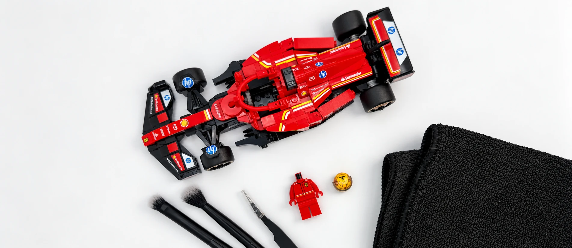Brick-built model, minifigure parts and cleaning tools arranged at the Brickora preparation station